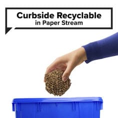 Scotch® Cushion Lock Expanding Paper Wrap B+ sustainable image. A hand places brown paper wrap into a blue recycling bin. Visible text includes: “Curbside Recyclable” and “in Paper Stream.”