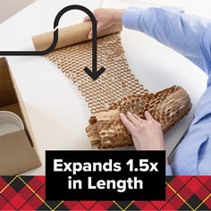 Scotch® Cushion Lock Expanding Paper Wrap B+ expanding image. A person stretches brown honeycomb paper wrap across a table to show how it expands. Visible text includes: “Expands 1.5x in Length.”