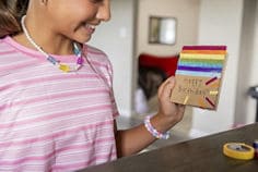 Photograph featuring a happy girl with a happy birthday card made with kids tape.