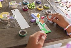 Photograph featuring kids hands using kids tape in craft projects.