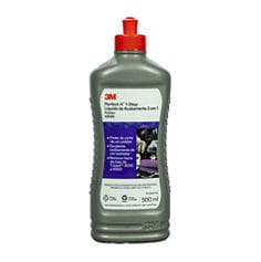 Vista frontal de uma garrafa cinza de 500 ml do 3M Perfect-It™ 1-Step Finishing Compound com tampa flip-top vermelha. O rótulo do produto apresenta o logotipo da 3M, o nome do produto e um painel informativo roxo descrevendo os benefícios de polimento e acabamento. A garrafa está centralizada sobre um fundo cinza-claro.
