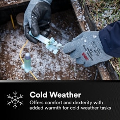 Shows a gloved hand performing a task in snowy conditions. Cold Weather, Offers comfort and dexterity with added warmth for cold-weather tasks.
