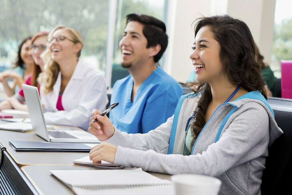 Doctors sitting together at table smiling. 